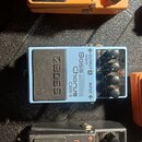 Tři kytarové efekty značky BOSS v kovovém provedení. Horní oranžový pedál má nápis Distortion PS-1, prostřední světle modrý Chorus CEB-3 Bass a spodn…