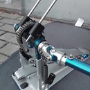 Modrá a stříbrná bicí pedál s dvěma černými plišovými beatery. Konstrukce je kovová, s viditelným řetězem a nastavitelnými mechanismy. Na nástroji ne…