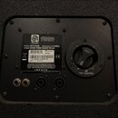 Zadní strana černého reproduktorového boxu s ovládacím panelem. Na stříbrném štítku je uveden nápis MADE IN THE U.S.A., logo Ampeg, MODEL: SVT410HE,…