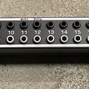 Černý rackový patchbay s kovovým předním panelem. Na levé straně je nápis ULTRAPATCH MULTI-FUNCTIONAL BALANCED PATCHBAY MODEL: PX1020. Zařízení obsah…