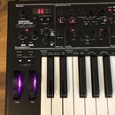 Černý syntetizátor s klaviatura s nápisem NOVATION AFX STATION. Přístroj obsahuje řadu otočných potenciometrů, tlačítek a červený digitální displej z…
