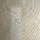 Detail spodní strany činchimu v přirozené barvě s viditelnými koncentrickými rýhami. Uprostřed je vyražen nápis STAMBUL, pod kterým je symbol měsíce…