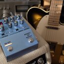 Modře stříbrný efektový pedál s nápisy BOSS a MD-200 MODULATION. Na horní straně se nachází pět ovládacích knoflíků, červený digitální displej zobraz…