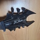 Černá hlava elektrické kytary s výrazným, špičatým tvarem. Na povrchu je bílý nápis B.C Rich a v samostatném políčku označení VIRGO. Na kytaru je nas…
