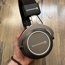 Šedé sluchátka s černým čelenem. Na horní části a na vnější straně mušle je bílý nápis beyerdynamic))))). Na vnitřní straně náušníku je vidět písmeno…