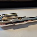 Stříbrný, kovový mouthpiece s U-tvarem. Povrch je hladký a lesklý, bez viditelných značek, log nebo nápisů. Nástroj vykazuje minimální známky opotřeb…