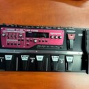 Černý loop pedal s výrazným růžovým ovládacím panelem. Na panelu je bílý nápis BOSS RC-300 LOOP STATION a digitální displej. V dolní části jsou pět č…