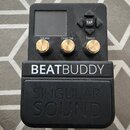 Černý efekt pedál s nápisem BEATBUDDY a pod ním vylisovaným logem SINGULAR SOUND. Zařízení má malý displej, čtyři šipkové tlačítka s nápisem TAP a tř…
