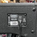 Detail zadní strany černého kytarového reproduktoru s texturovaným povrchem. Na kovovém štítku je logo Laney a nápisy DESIGNED & ENGINEERED IN THE UK…