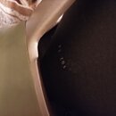 Detailní záběr na vnitřní část světle hnědého nebo béžového nástroje z plastu. Na tmavém vnitřním povrchu je vyražen bílý nápis 102 14. Povrch vykazu…