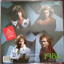 Fotografie zachycuje zadní obal vinylové desky s portréty čtyř mužů. V levé části je červený čtvercový štítek s seznamem skladek, včetně názvů JUMP a…