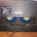 Zadní strana kytarového komba s černým texturovaným povrchem. Na zadním panelu je štítek s nápisy „Cambridge 30 Reverb Twin“, „Model No.V9320“ a znač…