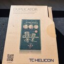 Kartonová krabice s produktem tChelicon Duplicator. Na balení je nápis DUPLICATOR a text Ultra-Simple Vocal Effects Stompbox with Doubling, Reverb an…
