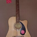 Akustická kytara s přirozenou dřevěnou barvou korpusu a tmavým hnedým hmatníkem. Na desce u otvoru je logo Fender a nápis CONCERT SERIES. Kytara má č…