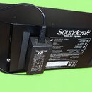 Zadní strana černého digitálního mixeru s nápisem Soundcraft a logy lexicon, dbx a DigiTech. K přístroji je připojen černý napájecí adaptér s nápisem…