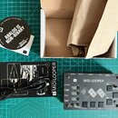 Na fotografii je černý MIDI looper s bílým nápisem B MIDI LOOPER a logem B. Zařízení obsahuje několik tlačítek, dva displeje a ovládací prvky s popis…