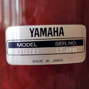 Detail stříbrného identifikačního štítku na červeném povrchu. Na štítku je uveden nápis YAMAHA, MODEL TT908 Y a SER. NO. LI-2238. Dole je uveden nápi…