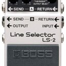 Kytarový pedál značky BOSS, model Line Selector LS-2. Zařízení má stříbrné kovové šasi s černým vypínacím pedálem, na kterém je vyražené logo BOSS. N…