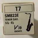 Bílá krabička s černými nápisy a siluetou tenorového saxofonu. Na obalu jsou uvedeny texty T7, SM823E, TENOR SAX., Sib - Bb a V16 EBONITE. Rohy krabi…