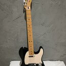Černá elektrická kytara s krčenkem z jasného dřeva a krémovým pickguardem. Na hlavě je nápis Fender Telecaster. Spodní část těla je opatřena bílým lo…