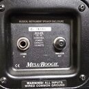 Detail zadní strany černého reproduktorového boxu s nápisem MUSICAL INSTRUMENT SPEAKER ENCLOSURE. Jsou zde dva konektory, u levého je nápis 8 OHMS IN…