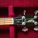 Hlava basové kytary v černé barvě s nápisem Gibson na okraji a ozdobným zlatým motivem uprostřed. Na zadní straně hlavy je nápis RD ARTIST BASS. Nást…