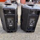 Dvě černé plastové aktivní reproduktory ztěla v zadním pohledu. Na zadní straně obou kusů je nápis C300z SOUND REINFORCEMENT SPEAKER SYSTEM a logo s…