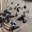 Sada chromovaných ladících kolíků na kytaru v rozloženém stavu. Soubor obsahuje šest ladících mechanismů s kovovými knoflíky a několik doprovodných š…
