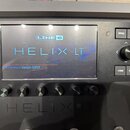 Detailní pohled na kytarový procesor Line 6 Helix LT. Na displeji je zobrazeno logo LINE 6 a nápis HELIX LT spolu s textem Firmware Version 3.80.0. V…