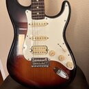 Elektrická kytara s tmelem v provedení sunburst a bílým pickguardem. Nástroj má tři snímače typu single-coil, jeden trestkový spínač a tři otočné pot…