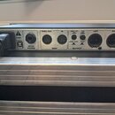 Zadní strana stříbrného elektronického zařízení s několika konektory. Jsou zde nápisy FUSE: F0.5A L, HEAD PHONE, MIDI s rozdělením THRU/OUT a IN, OUT…