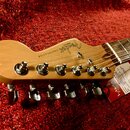 Hlava elektrické kytary v přirozené dřevěné barvě s nápisy Fender, STRATOCASTER a made in USA. Na hřideli jsou umístěny šest chromovaných ladiček. Ko…