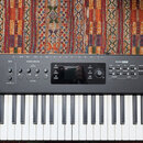 Černý digitální klavír s bílými a černými klávesami. Na levé straně je nápis studiologic a na pravé straně numaxPIANO. Horní panel obsahuje displej,…