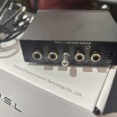 Černý phono předzesilovač s nápisem PH-1 MM PHONO AMPLIFIER. Na přední straně jsou dva vstupy označené MM IN (R, L), vypínací přepínač a dva výstupy…