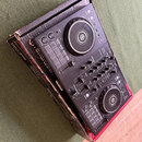Černý DJ 컨트롤러 v originálním kartónovém obalu. Na zařízení je vidět logo Pioneer DJ a označení modelu DDJ-400. Ovládání obsahuje dva jog-wheels, fader…