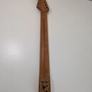 Dřevěný krk elektrické kytary s hnutou hlavou a šesti otvory pro ladičky. Na zadní straně krku je vyryté logo „WAQUOTH“, nápis „BY FENDER“ a čísla „5…