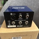 Modrý kovový box s černým zadním panelem. Na panelu jsou nápisy MicSim, OUT SPEAKER, OUT LINE a INPUT FROM AMPLIFIER s označením 4Ω, 8Ω a 16Ω. Je zde…