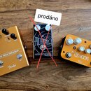 Tři kytarové efekty na dřevěném povrchu. Zleva je zlatý pedál s nápisy MTG TUBE TREMOLO a Fender, uprostřed černý pedál s nápisy EPOCH DUST a catalin…