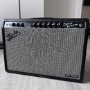Kytarový zesilovač s černým krytím a šedou tkanou mřížkou. Na horním ovládacím panelu jsou knoflíky a nápisy NORMAL, VIBRATO, VOLUME, TREBLE, BASS, R…