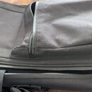 Černý textilní pouzdro s několika zipovými přihrádkami. Na přední části je umístěna malá čtvercová nášivka s bílým logem připomínajícím stylizované p…