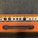 Horní panel kytarového komba značky ORANGE, model ROCKER 30. Panel obsahuje vstup INPUT, šest otočných knoflíků s popsaky NATURAL VOLUME, DIRTY GAIN,…