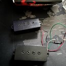 Dvě černé humbuckery s viditelnými póly. Na obou je vyražen nápis DiMarzio. Z pickupů vedou červené, černé, bílé a zelené vodiče.