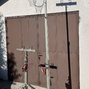 Na fotografii jsou dva kovové stativy stříbrné barvy s žlutými a černými varovnými pruhy na nohách. Stativy jsou vybaveny červenými klikami a horními…