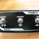 Černý nožní spínací pedalboard s třemi kovovými spínači. Na horní straně je bílé logo DigiTech a nápisy MODE, DOWN a UP nad jednotlivými spínači. Ve…