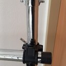 Detail chromovaného stojanu s dvěma spojovacími klouby. Horní kloub je kovový s motýlkovým šroubem, spodní spojovací prvek je z černého plastu s kovo…