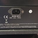 Zadní strana černého hudebního zesilovače s napájecím vstupem a dvěma pojistkovými sloty. Jsou zde nápisy HT FUSE T500mAL, MAINS FUSE (T1.6AL - 230V)…