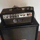 Černý kytarový zesilovač s nápisem ENGL na přední mřížce, umístěný na černém kytarovém reproduktoru značky Blackstar. Zesilovač má kovový ovládací pa…