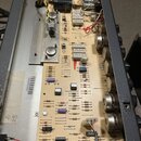 Fotografie zachycuje vnitřek elektronického zařízení s otevřeným šasi. Je viditelná základní deska s osazením komponentů, jako jsou rezistory, konden…