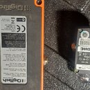 Fotografie zachycuje spodní stranu dvou efektů. Levý je oranžový s nápisem Digitech a štítkem, na kterém jsou uvedeny údaje jako Digitech Switch Sand…