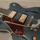 Kytara s polodupatým tělem v tmavě modré barvě a hnědým vzorovaným pickguardem. Na pickguardu je bílý nápis GREISCH. Nástroj má dva zlaté humbuckery,…